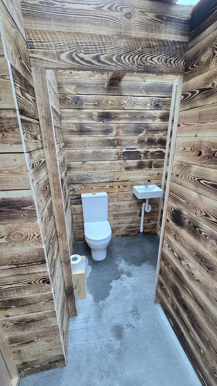 A toilet and hand basin in the timber-lined WC facilities at Hveradalir