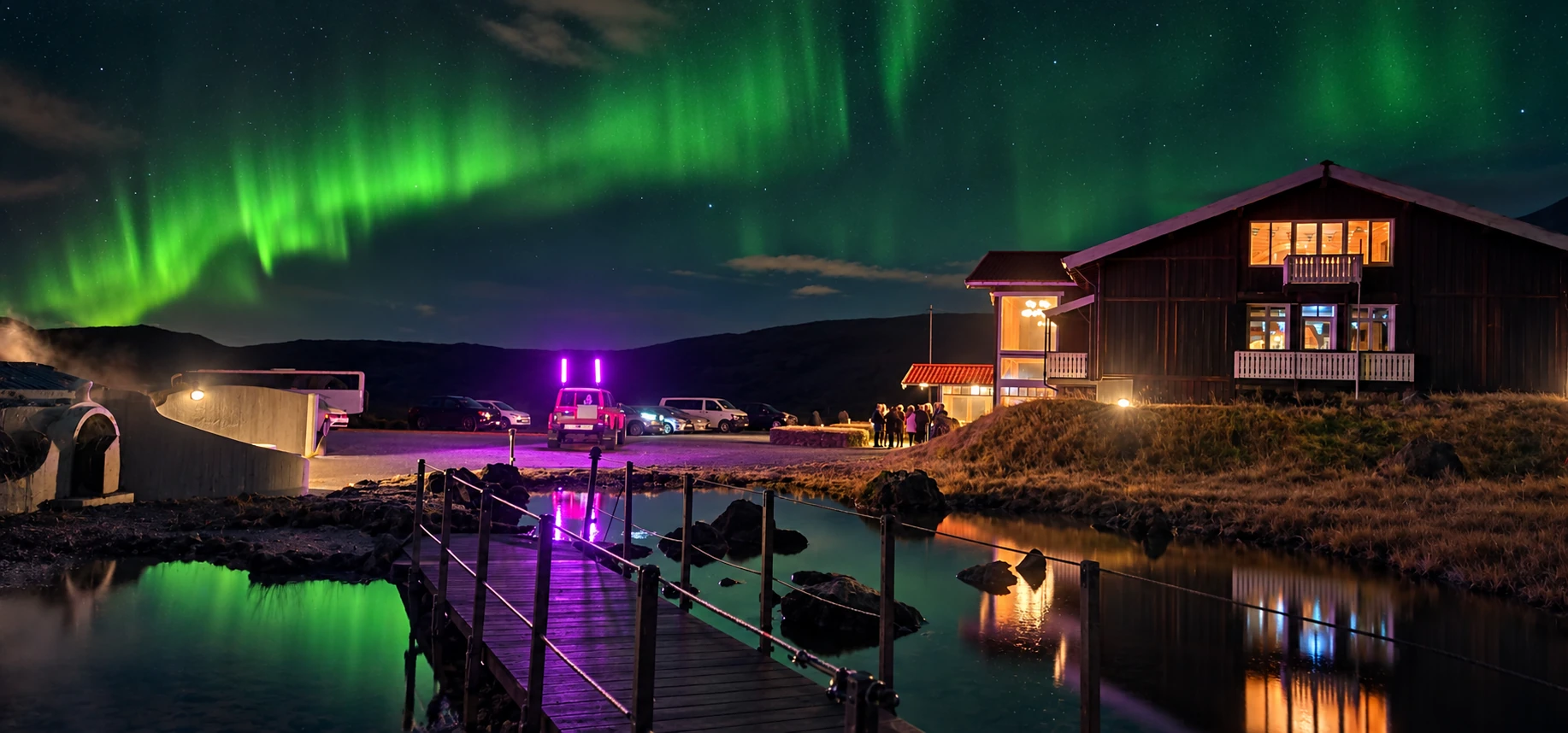 Northern lights over the Hveradalir lodge reflected in geothermal pools beside a boardwalk