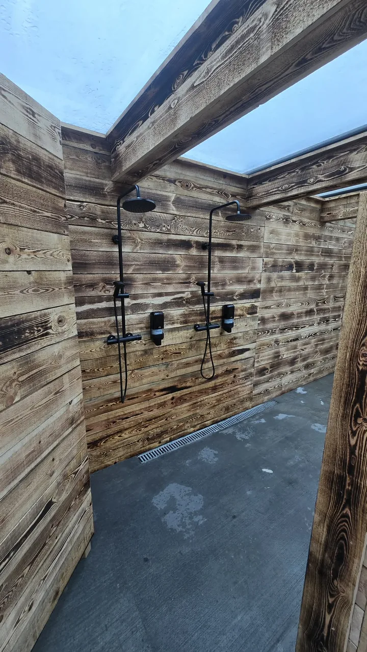 Two showers in the timber-lined facilities at Hveradalir